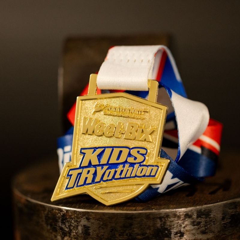 Metal Weet-Bix Kids TRYathlon custom event medal with a bright gold finish. The event's logo is coloured in with enamel. 