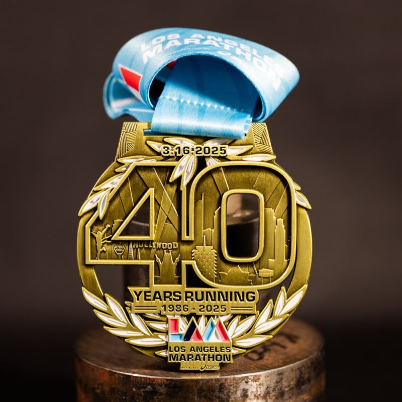 Metal Nike Melbourne Marathon custom event medal with antique gold finish. The marathon's logo is coloured in with enamel. The medal features a cut out that doubles as a bottle opener in its centre. 