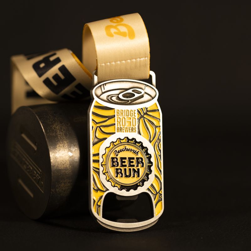 Beechworth Beer Run custom event medal with antique gold finish. The marathon's logo is coloured in with enamel. The medal features a cut out that doubles as a bottle opener in its centre. 